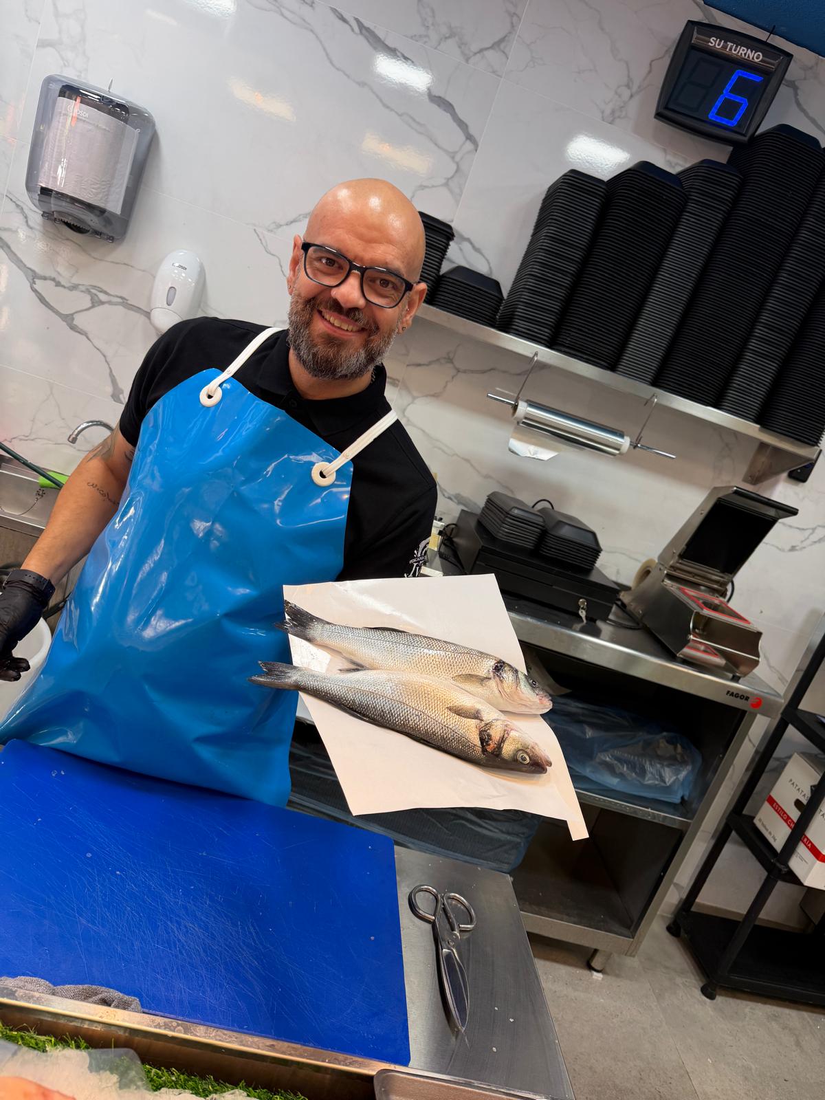 Iván, tu pescadero, mostrando un par de lubinas antes de prepararlas